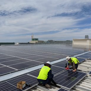 Connect Energy professionals installing a commercial solar panel array on a rooftop.