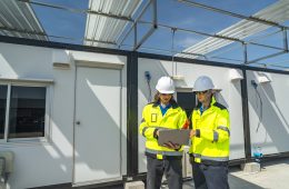 Two engineers in high visibility jackets and helmets working on
